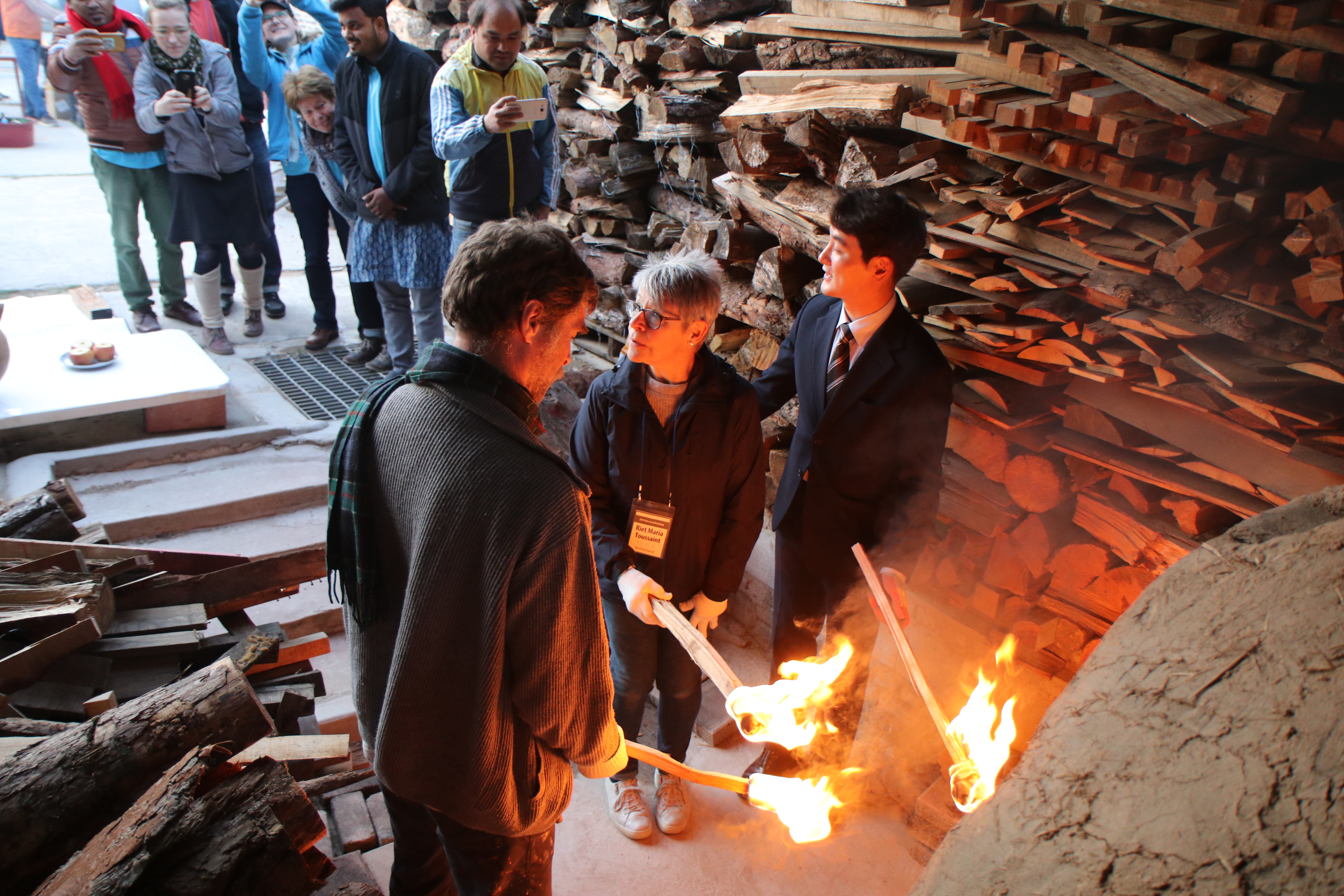 Het aansteken van het vuur door de oudste mannelijke en vrouwelijke deelnemer (ik) van de workshop en een official